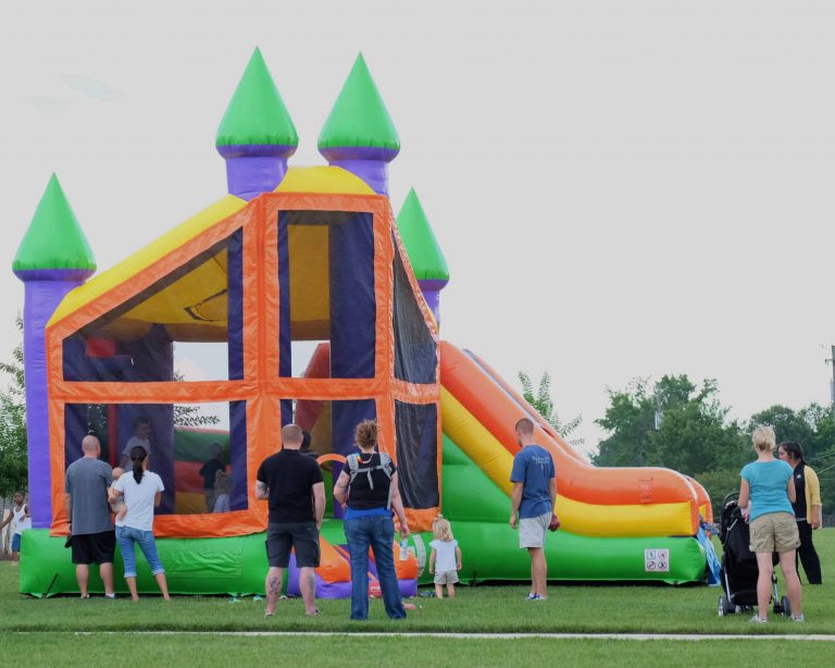 Large inflatable bounce house with slide and kids playing outdoors in Montgomery TX