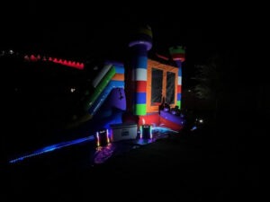 Guide to bounce house rentals image featuring glowing inflatable bounce houses at a nighttime event in Montgomery, TX