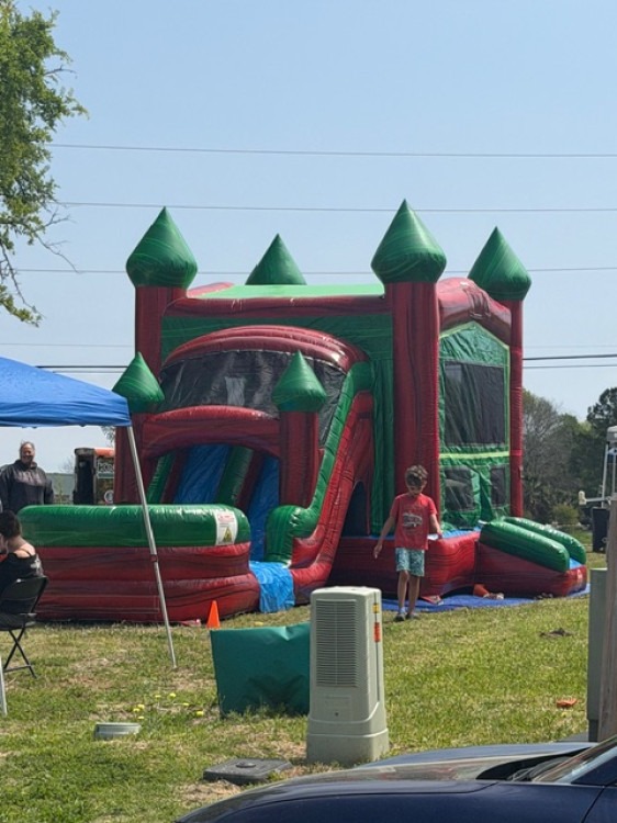 Large bounce house with slide set up at a community event in Montgomery, TX